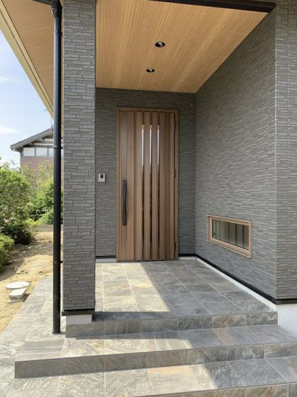 Крыльцо дома с деревянной дверью из планок