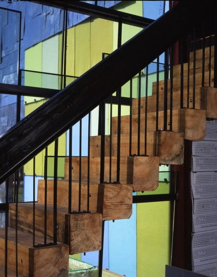 Дизайн лестницы со ступенями из деревянных бревен и стальными поручнями
