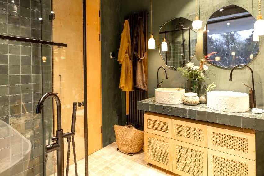 Небольшая ванная комната с оливковыми стенами, двойной раковиной и травертиновым полом.