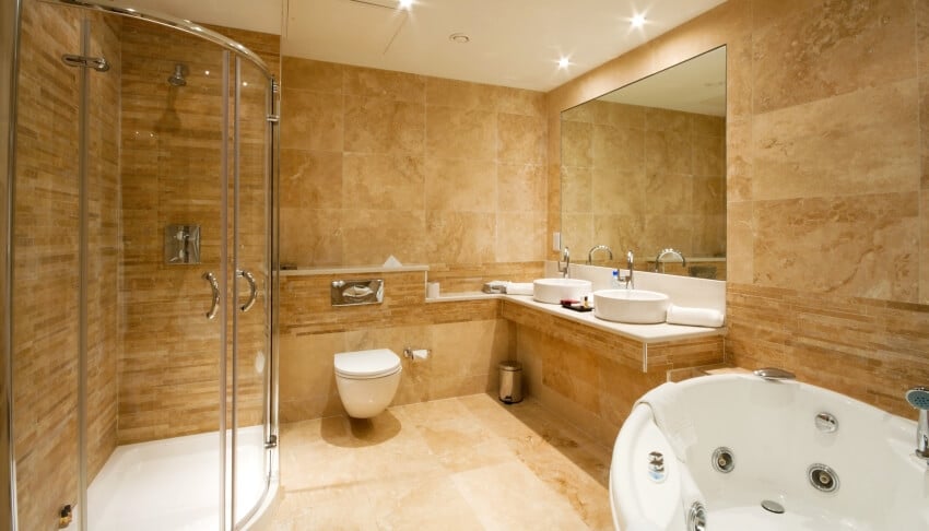Травертиновый пол в ванной комнате с двойной раковиной и душевой кабиной