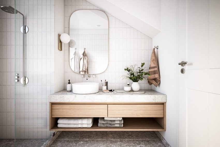 Ванная комната со столешницей из каррарского мрамора, зеркалом, раковиной, душем, плиткой и деревянным ящиком.