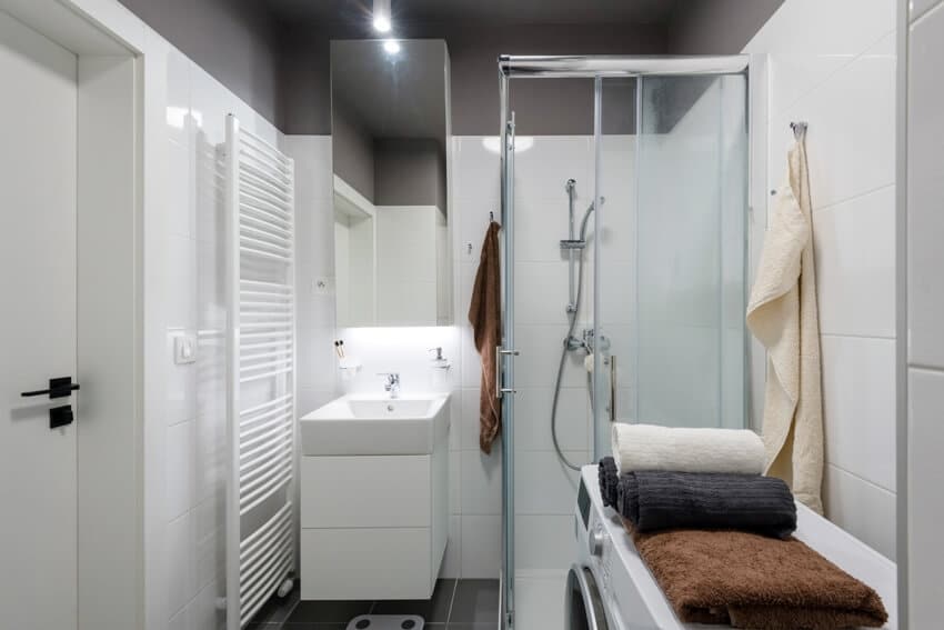 Белый небольшой интерьер ванной комнаты с душевой дверью из матового стекла
