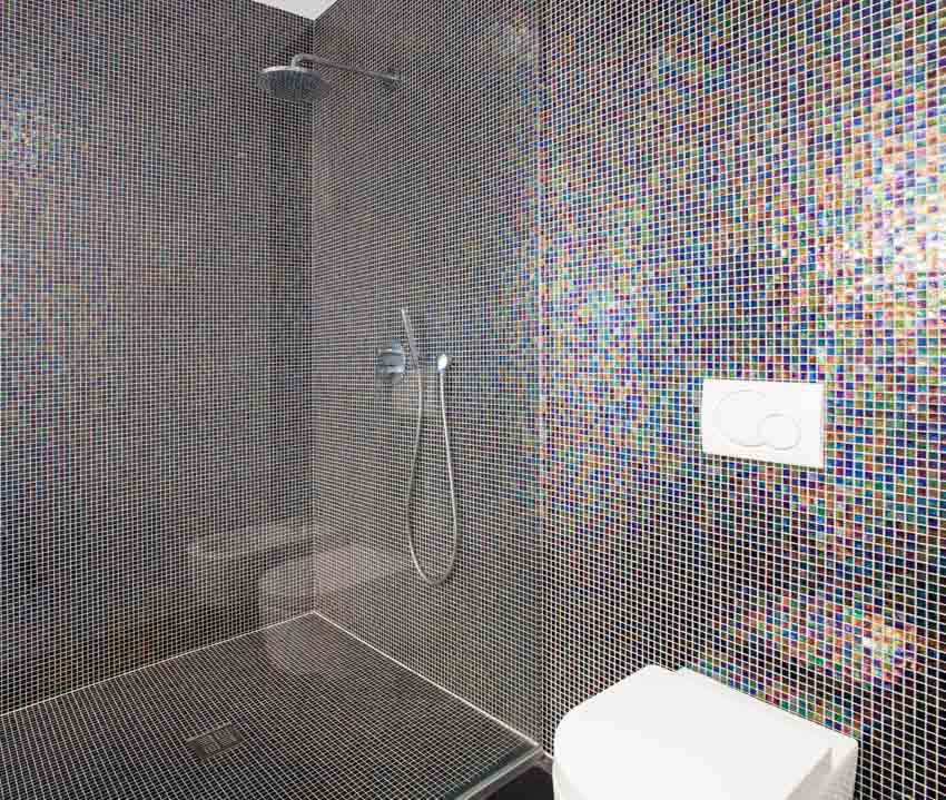 Ванная комната с душевой стеной из стеклянной мозаичной плитки, стеклянной перегородкой и туалетом
