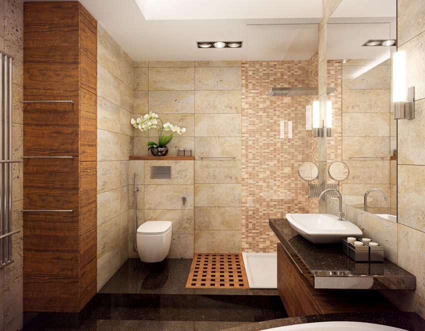 Ванная комната с мозаичной плиткой, душем, туалетом, туалетным столиком, столешницей, раковиной, зеркалом и потолочными светильниками.