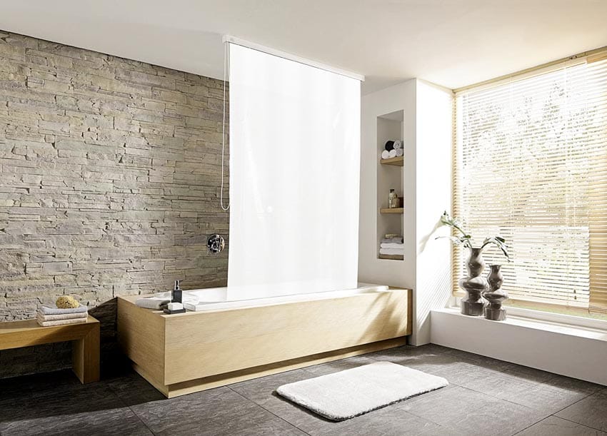 Ванная комната с рольставнями для занавесок для душа с каменной стеной, ванной, кафельным полом и жалюзи на окнах.