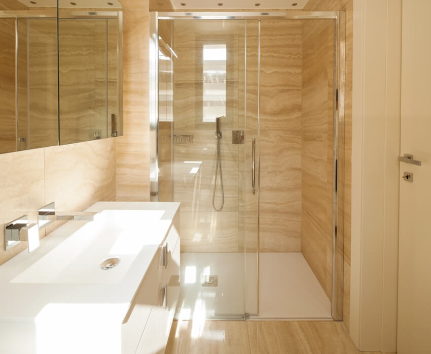 Ванная комната с ламинированными душевыми стенами и стеклянными дверями с белой раковиной и зеркалом