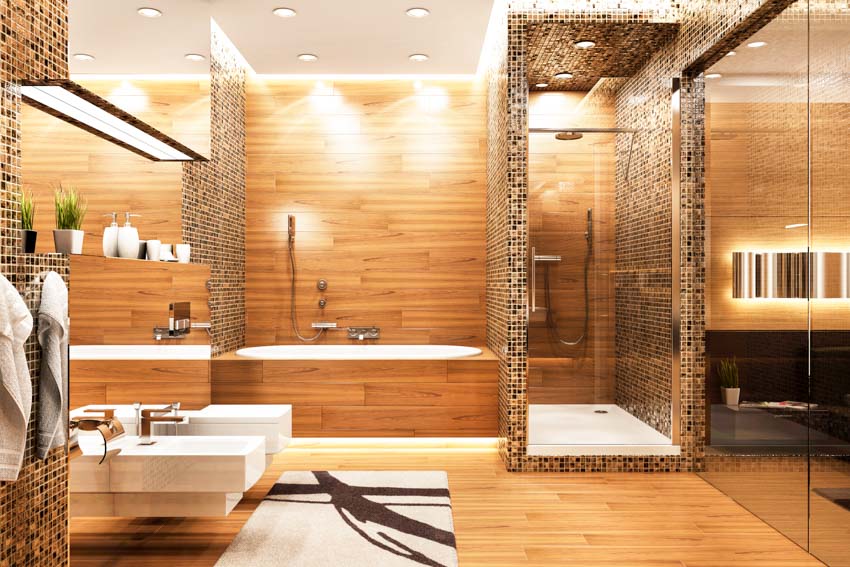 Ванная комната с туалетом, биде, душевой кабиной из стеклянной плитки, деревянным акцентом, настенной ванной и зеркалом.