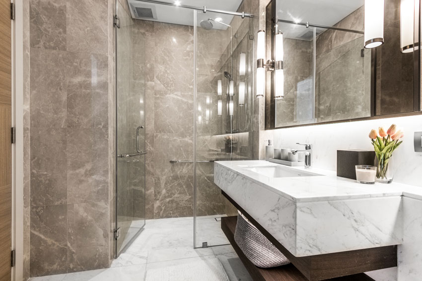 Ванная комната с душевыми стенками, плавающей раковиной, столешницей, зеркалом и стеклянной перегородкой.