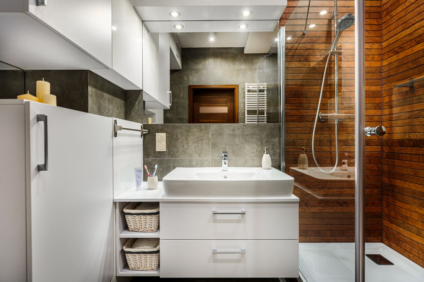Ванная комната с душевой стенкой из композитных ПВХ-панелей, стеклянной перегородкой, раковиной, ящиками и шкафчиками