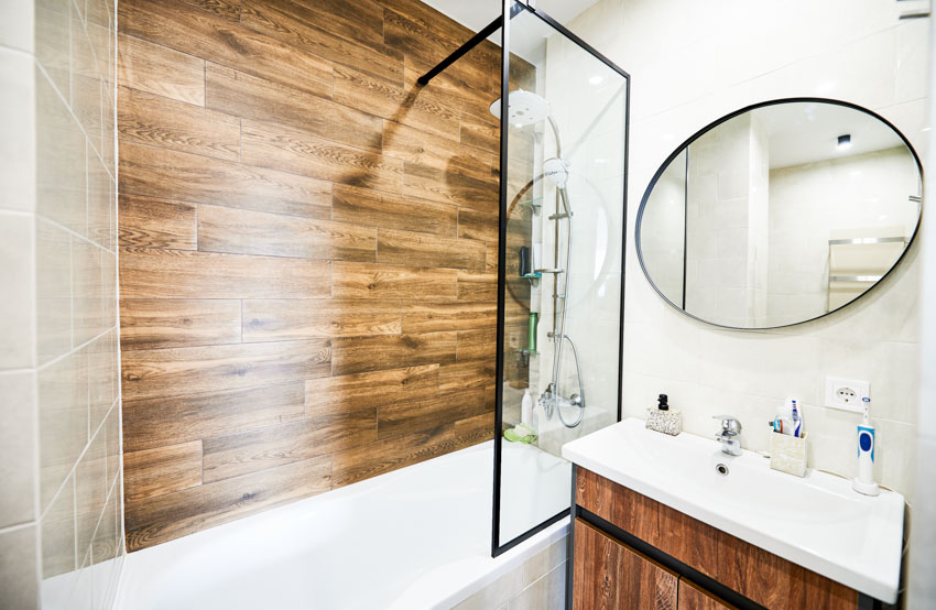 Ванная комната с ламинированной стеновой панелью, душевой стенкой, насадкой для душа, раковиной и зеркалом