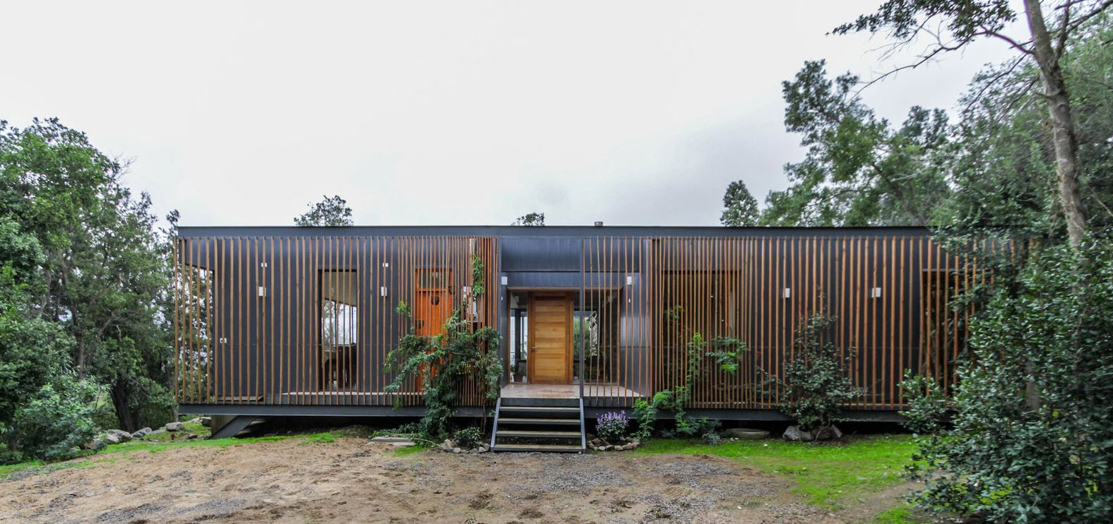Фасад современного загородного дома из дерева и металла