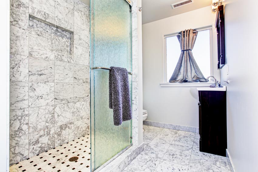 Ванная комната с гранитной душевой кабиной, стеклянной дверью, держателем для полотенец, окном и занавеской
