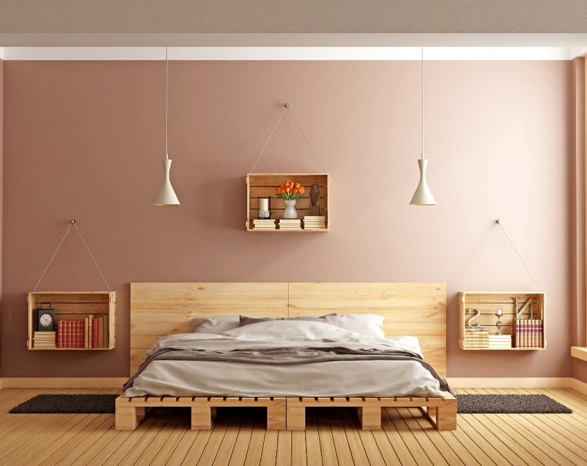 Современная минималистская спальня с коричневой краской для стен, кроватью из поддонов и деревянными ящиками, используемыми в качестве тумбочек