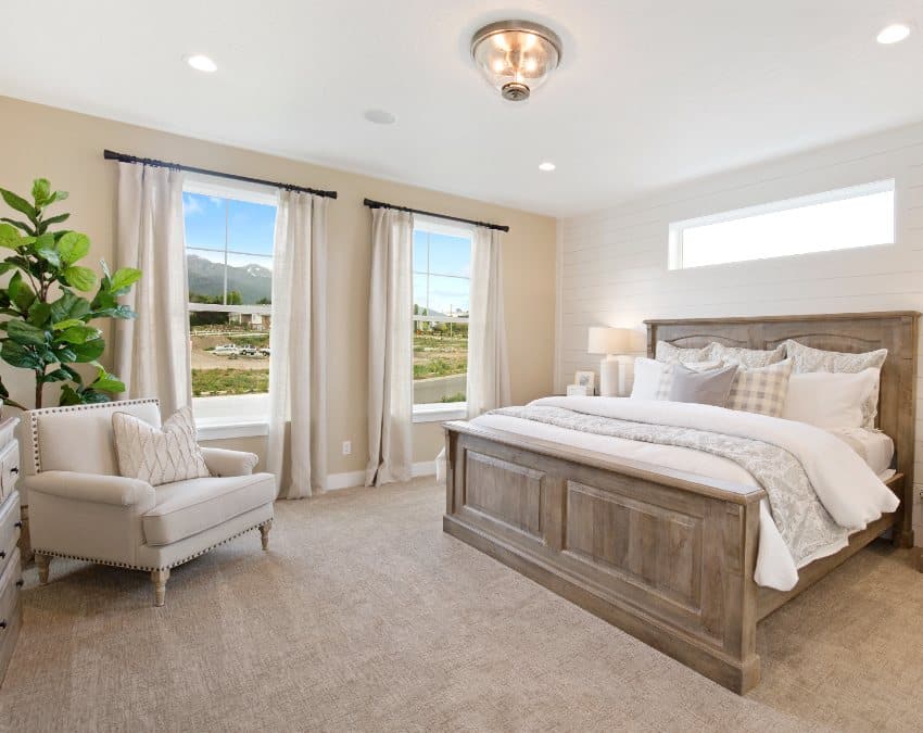 Роскошная новая бежевая спальня с белой и коричневой мебелью и большими негабаритными окнами