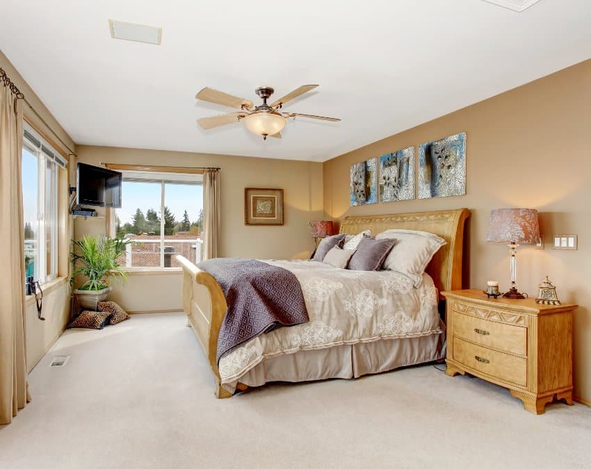 Классическая главная спальня в коричнево-кремовом интерьере с деревянной мебелью и красивыми постельными принадлежностями