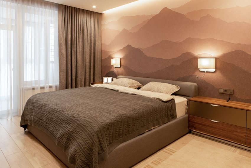Спальня с окрашенной акцентной стеной, матрасом, подушками, окном, шторами, тумбочкой и настенными бра