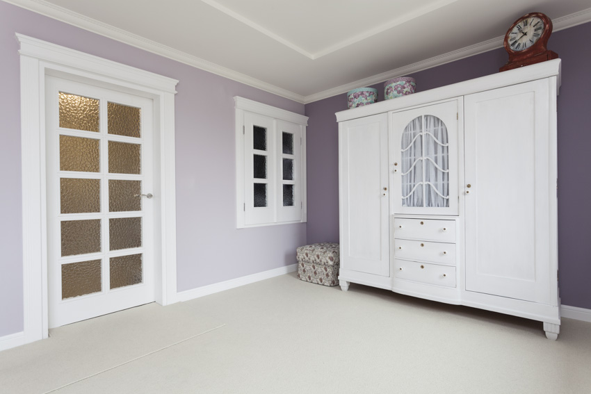 Спальня со шкафом, стеклянной дверью и окрашенной в лавандовый цвет стеной