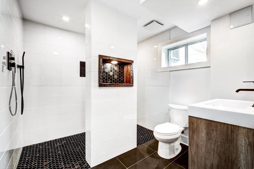 Ванная комната с черным плиточным полом, белыми стенами, душем, туалетом, раковиной и окном