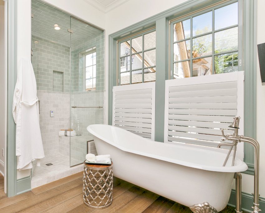 Красивая ванная комната с отдельно стоящей ванной, деревянными полами и потолочной плиткой для душа
