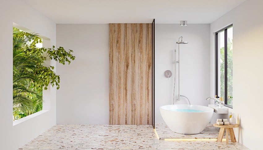 Белая ванная комната с деревянным акцентом на стене и отдельно стоящей ванной