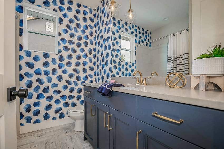 Симпатичная ванная комната с голубыми стенными акцентами и шкафами