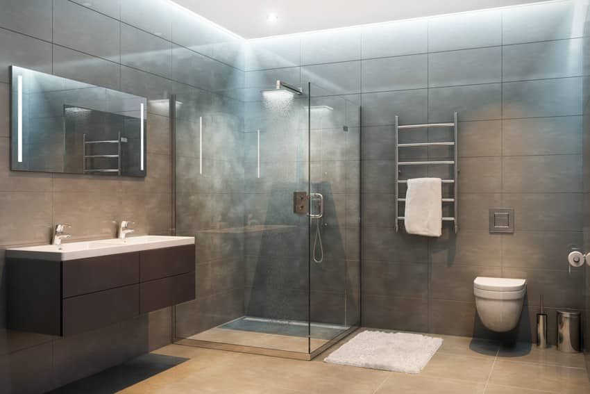 Ванная комната со стеклянной душевой кабиной, плиткой от пола до потолка, плавающей раковиной, зеркалом, унитазом, зеркалом и держателем для полотенец.
