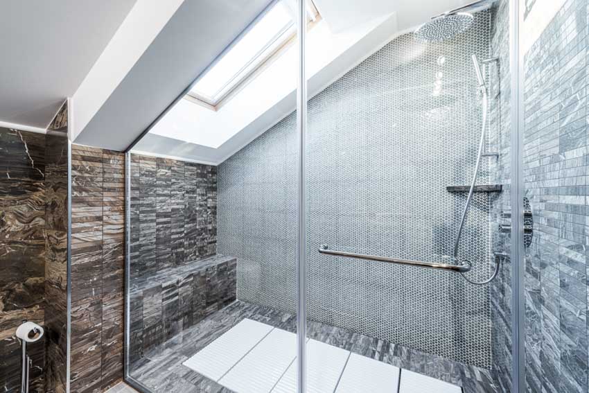 Ванная комната с каменной плиткой от пола до потолка, стеклянной дверью, душевой и световым окном