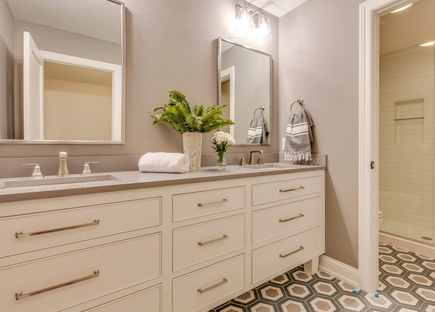 Потрясающий интерьер ванной комнаты с окрашенной ламинированной столешницей, косметическими зеркалами и узорчатым кафельным полом