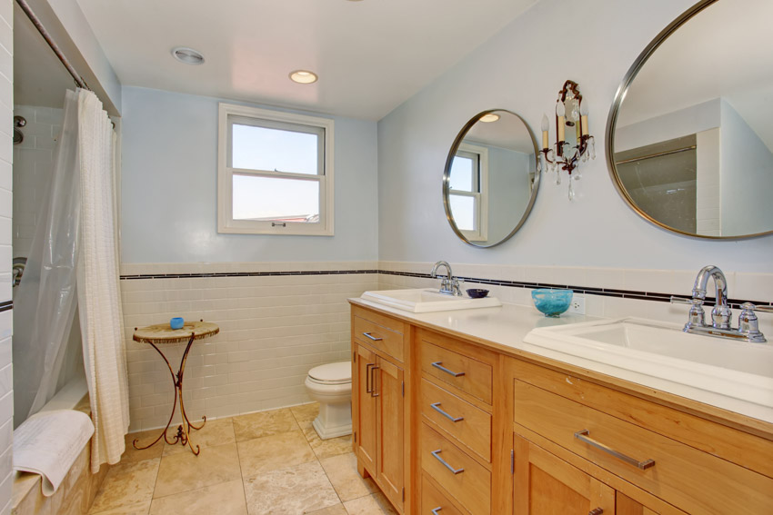 Ванная комната с полиэстеровой занавеской для душа, зеркалом, шкафчиками, ящиками, столешницей и смесителем.