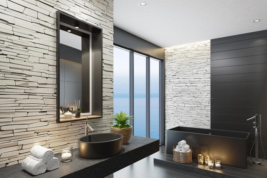Красивая ванная комната с черной столешницей, раковиной, зеркалом, ванной и окном