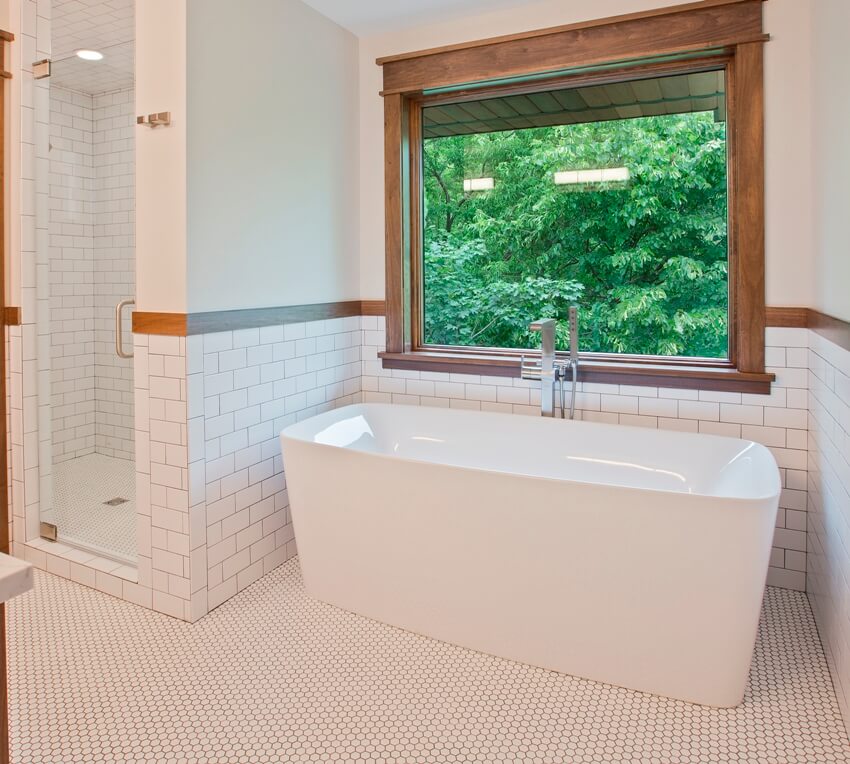 Великолепная ванная комната с полом из пенни-плитки, отдельно стоящей ванной и отдельной душевой кабиной.