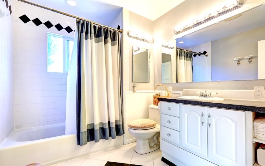 Светлая ванная комната с белым шкафом, кафельным полом, ванной и занавеской на регулируемой штанге