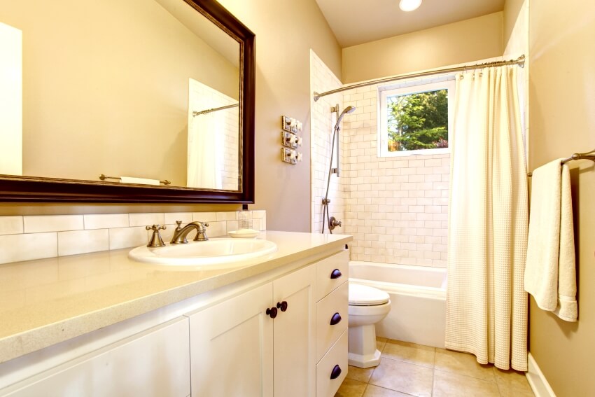 Светлый интерьер ванной комнаты с белым шкафом и стеной из кирпичной плитки в душе с изогнутым карнизом
