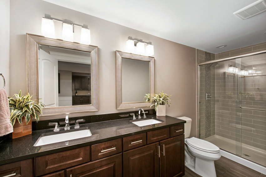 Ванная комната с косметическим зеркалом, столешницей из мыльного камня, деревянными шкафчиками, туалетом и душевой.