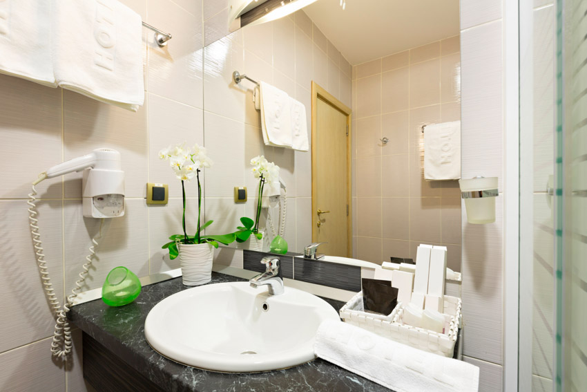 Зеркало в ванной комнате со столешницей из мыльного камня, раковиной и смесителем