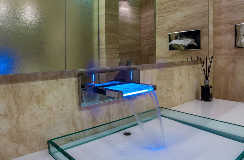 Ванная комната с современным краном, раковиной, зеркалом и фартуком