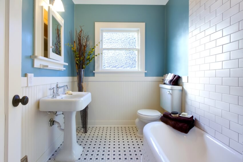 Роскошная старинная синяя ванная комната с раковиной на пьедестале, стеной из плитки метро и полом из мозаичной плитки