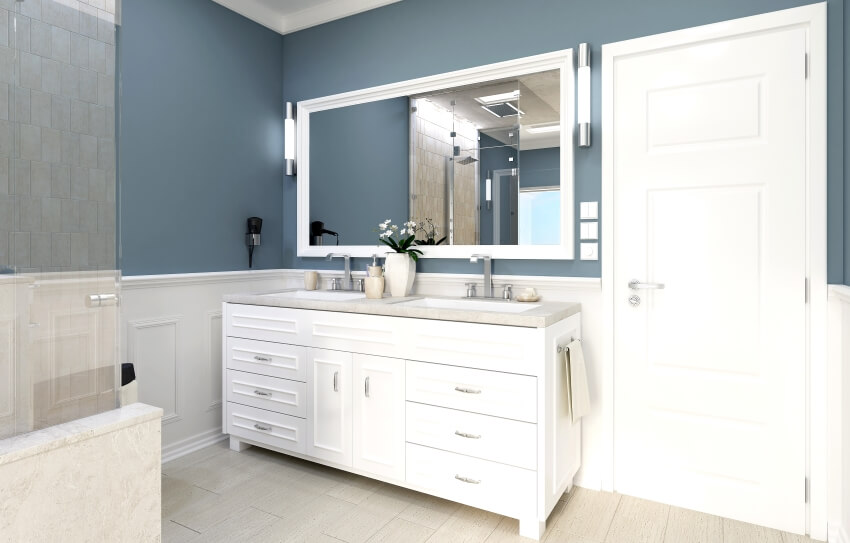 Классическая ванная комната с бело-голубыми стенами и туалетным столиком с двойной встроенной раковиной.