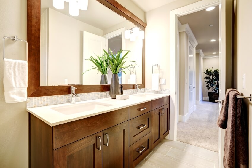 Белый и чистый дизайн ванной комнаты с тумбочками из темного дерева и бра