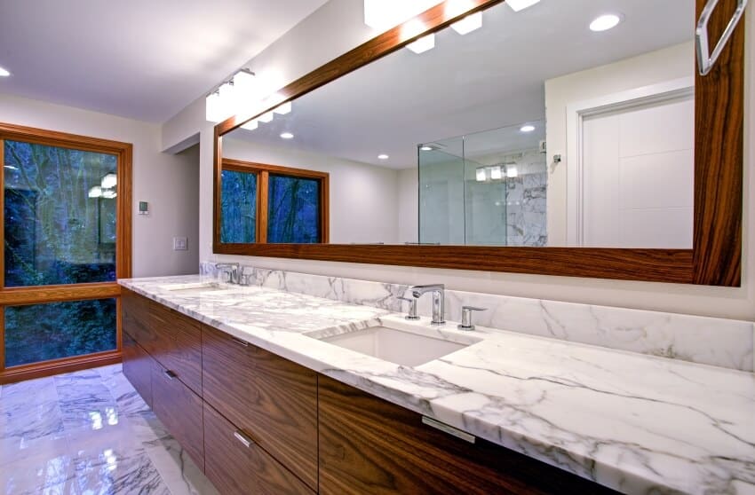 Элегантная ванная комната с двойным туалетным столиком, столешницей из мрамора Calacatta и встроенной раковиной.