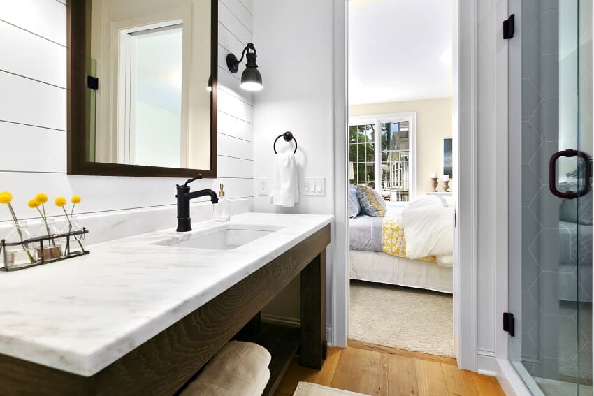 Квадратное зеркало и бра на стене в ванной с открытыми полками для хранения