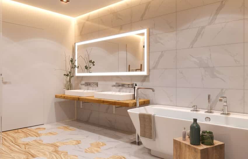Ванная комната с раковиной, деревянным плавающим туалетным столиком, отдельно стоящей ванной и потолочными светильниками со светодиодной лентой.