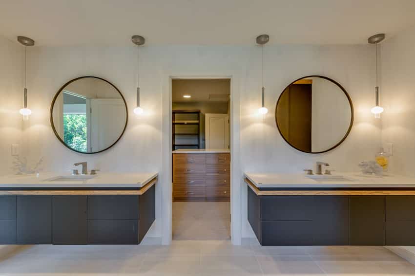 Ванная комната с двумя плавающими раковинами, круглыми зеркалами и подвесными светильниками