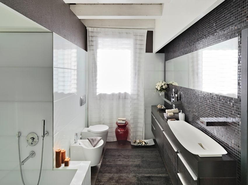 Ванная комната с мозаичной плиткой на стене, потолочными балками, черным ковром и темным туалетным столиком