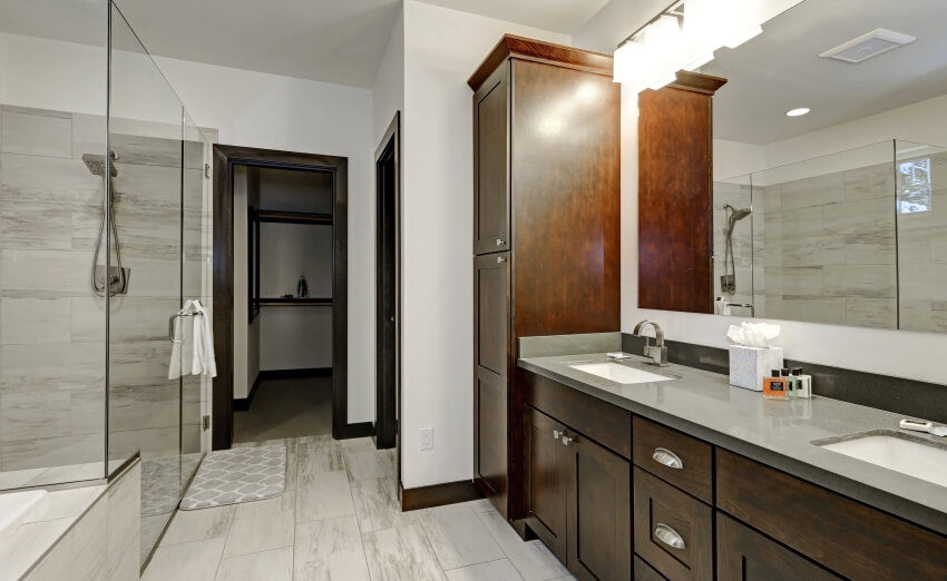 Главная ванная комната с деревянными шкафами, столешницей из серой краски и душевой кабиной.