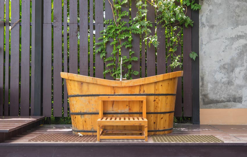 Открытая площадка с ванной в японском стиле и деревянным забором