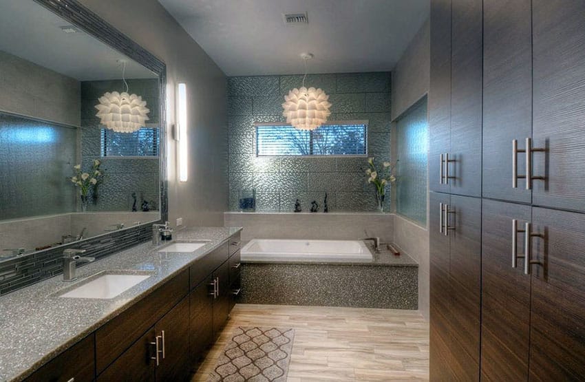 Современная ванная комната с коричневой тумбой и подвесной люстрой над ванной