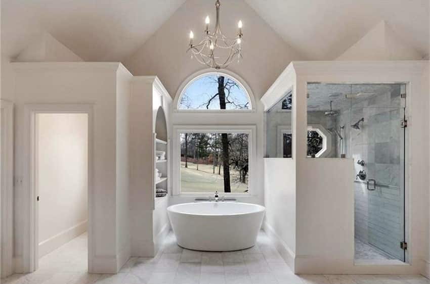 Красивая белая мраморная современная ванная комната с люстрой и высокими потолками