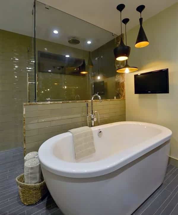 Современная главная ванная комната с полом из сланцевой плитки, отдельно стоящей ванной и черными подвесными светильниками.
