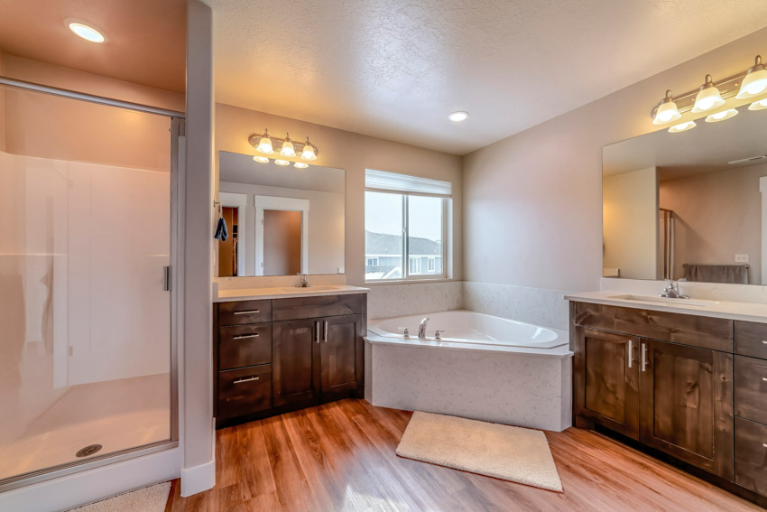 Ванная комната с акриловой ванной, душевой, деревянным полом и акцентным освещением